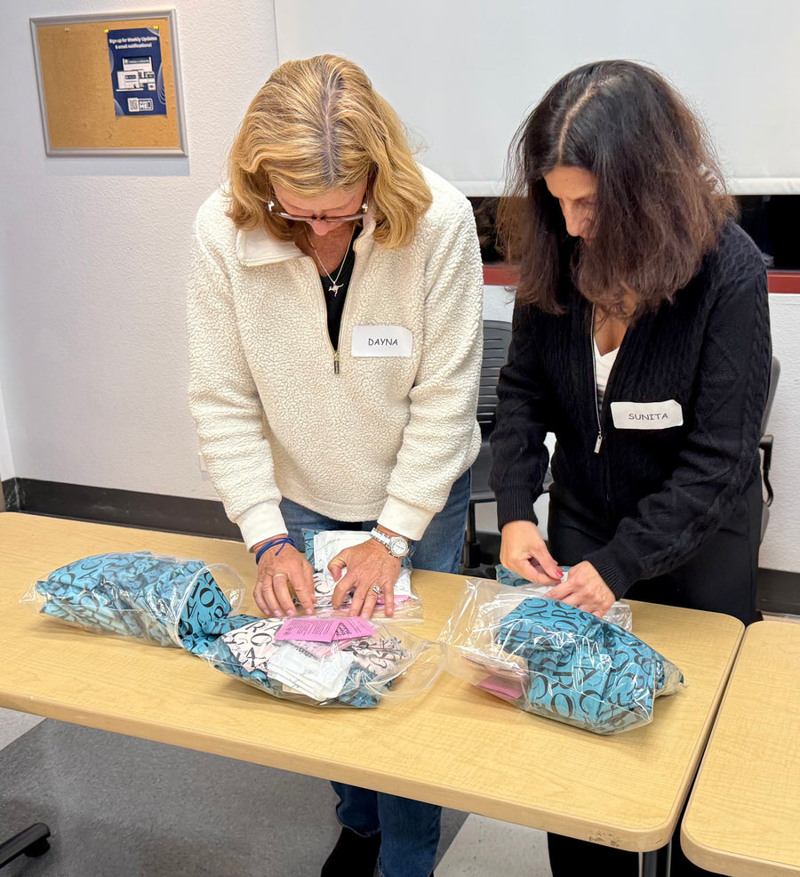 Two volunteers preparing packages of personal-care supplies